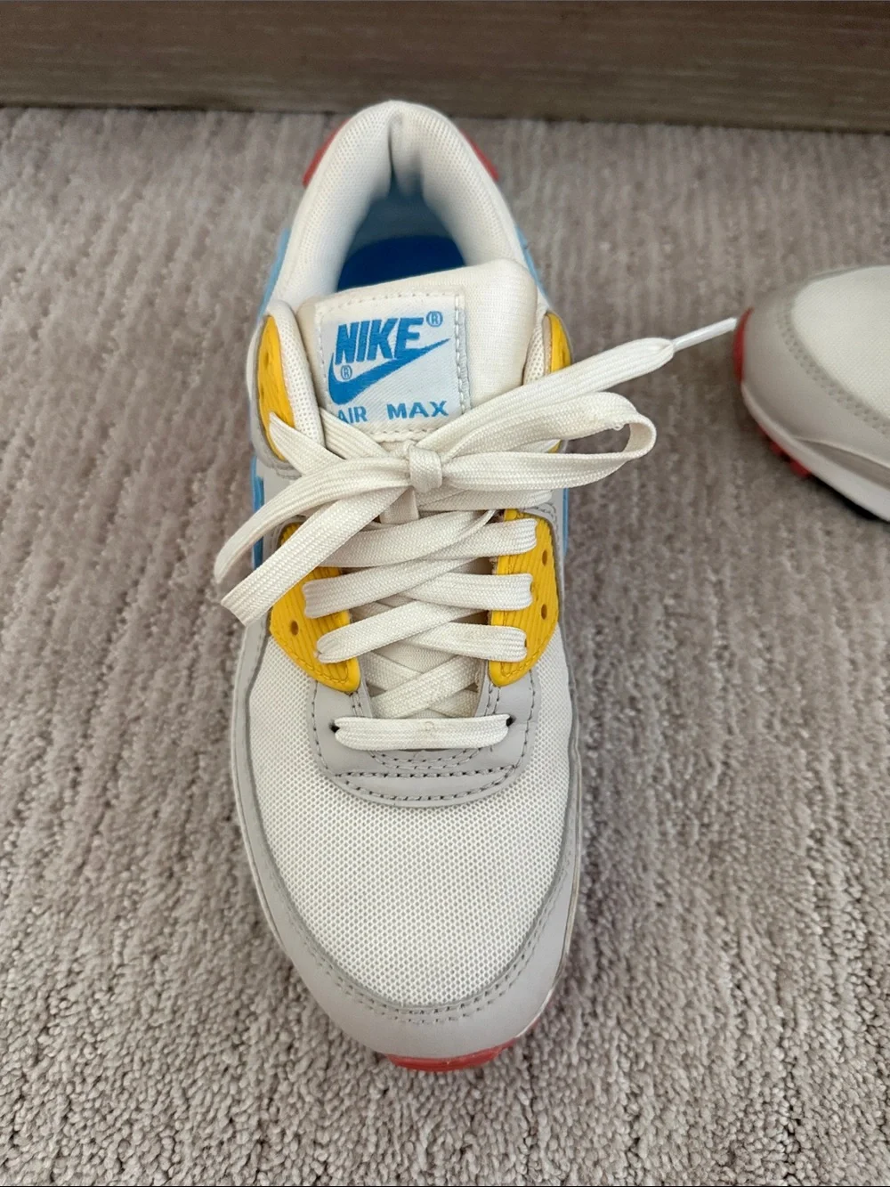 Nike White Sneakers with Blue Swoosh, Yellow Eyelets & Red Accents